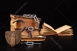 Old books strapping a shiny chain. Prohibited literature open to readers