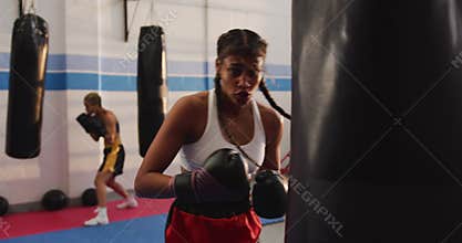 Mixed race woman boxing in punchbag