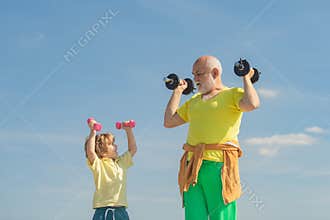 Senior man and child in family health club. Sportsman grandfather and healthy kid with dumbbell exercise. Grandfather