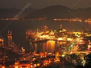 Sailboats anchored in harbor night scene