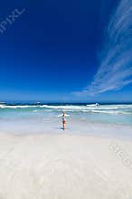 A girl running towards the sea on clifton beach in the capetown area of south africa.