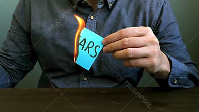 Conceptual video of the fight against fear. A man burns a sheet with the sign.