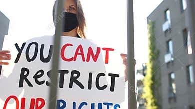 You cant restrict our rights. Close portrait of a girl in a mask with a poster. Social protests in Europe during