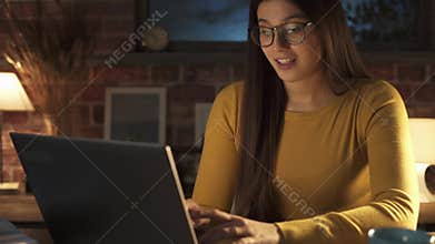 Happy woman chatting with her laptop at night