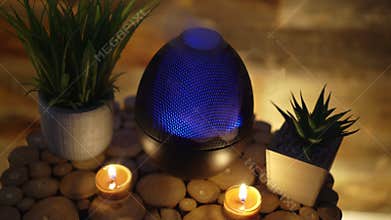 Aroma electric oil diffuser lamp, candles on wooden table in room. Aromatherapy, 4k