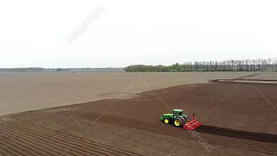 Aero. Agricultural field, tractors with special equipments plow soil, planting potatoes. Automated planting of potatoes