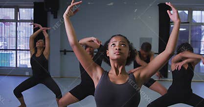 Multi-ethnic group of fit female modern dancers practicing a dance routine