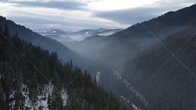 Drone flight through dramatic, snowy winter mountain range. Aerial landscape of the Alps in Europe during winter season