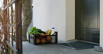 contactless delivery - delivery man leaves grocery box at the home door