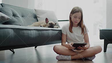 Pretty Girl Sits on the Floor Near Sleepy Pet.