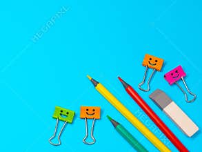 Smiles Binder Clips with Yellow, Green and Red Pencils on Blue Background