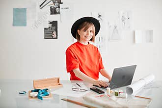Smiling girl fashion designer blogger working in studio. Photography for blog or ad educational courses or clothing