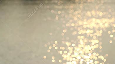 Bokeh of sunlight reflected on the water surface.