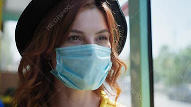 Young woman rejoices at lifting of quarantine and taking off her medical mask to protect against virus and infection