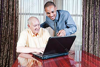 Young Man and Senior Male Working on Computer