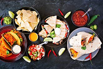 Mexican food table scene, top view on a dark slate background