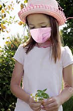 Girl with safety mask picks flowers