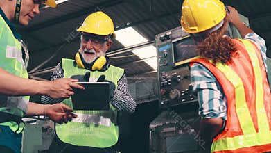 Group of factory workers using machine equipment in factory workshop