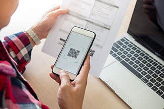 The butler is using a mobile phone to scan the QR code for the bill through the app. Convenient, fast, is an option of modern