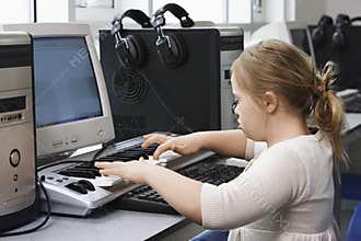 Girl (10-12) with Down syndrome playing keyboard