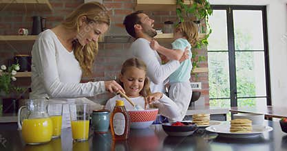 Family preparing food on worktop in kitchen at comfortable home 4k