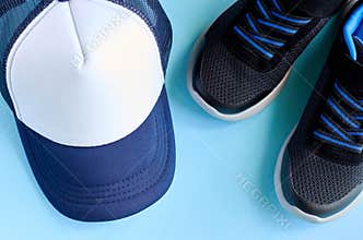 Baseball cap and sneakers on blue background composition