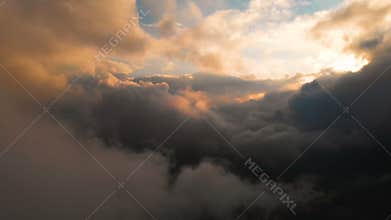 Span camera through the evening rain clouds at sunset above cloud levels. Fabulous flight in the clouds. Aerial view