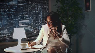 African american business woman in eyeglasses speaking by smartphone with something