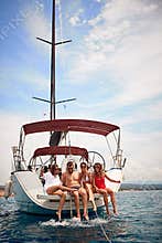 Friends having fun on a sailboat at summer party