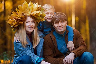Happy Parents with a child on a walk in the fall. Family
