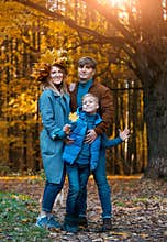 Happy Parents with a child on a walk in the fall. Family