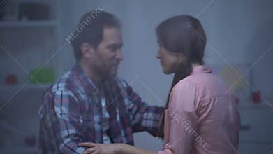 Man and woman hugging at room on rainy day, reconciliation after quarrel