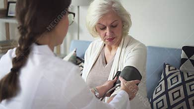 Physician visit old lady at her house to measuring pressure