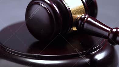 Close-up of a wooden hammer of a judge or auction knocks on a wooden surface