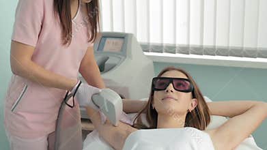 Beautiful woman having her armpit hair removed by female beautician in spa slow motion