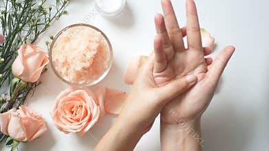 4K. natural skincare concept. woman apply white cream on her hands on white background with jar of cosmetic cream, salt spa scrub