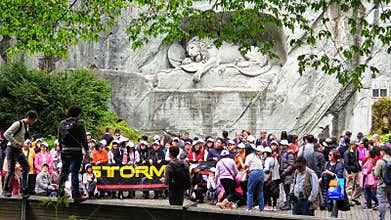Mass tourists taking a group picture in front of Lion monument, Lucerne Switzerland