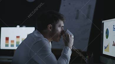 Focused business analyst watching financial graph in night office
