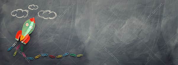 Education. Back to school concept. rocket cut from paper and painted over blackboard background. top view, flat lay. banner