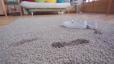 Dirty footprints and shoes on the carpet