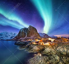 Aurora Borealis above Reine, Lofoten islands, Norway. Nothen light, mountains and houses. Winter landscape at the night time.