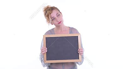 Happy beautiful blonde woman thinking while holding blackboard