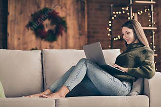 Full length profile side photo of charming positive girl enjoy her christmas time vacations lying on divan type email to