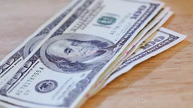 Man Lays Down One Hundred Dollar Bills On Table Top