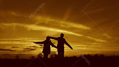 Children play in the evening at sunset. concept of a happy childhood. children dream of flying. Superhero girls running