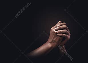 Praying hands with faith in religion and belief in God on dark background. Power of hope or love and devotion