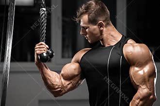 Muscular man workout in gym doing exercises for biceps, strong bodybuilder male showing biceps