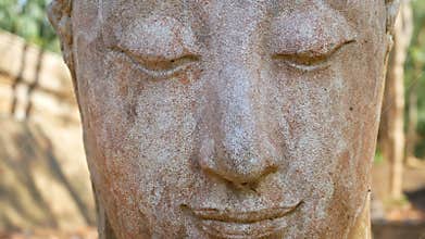 4K. Calm and peaceful face of old worship buddha statue head illuminated. Buddha statue at Chiangmai history temple. Chiang Mai