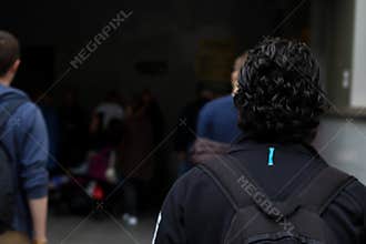 Students at the university campus. People in the corridors of the educational building. A student with a backpack from the back