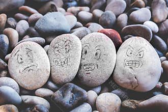 Managing emotions emoji faces on stones - sad, happy, surprised worried and angry feelings draw
